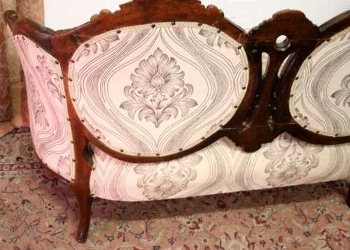 An exquisite antique Victorian carved settee with stylish new upholstery.