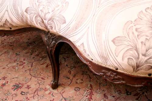 An exquisite antique Victorian carved settee with stylish new upholstery.