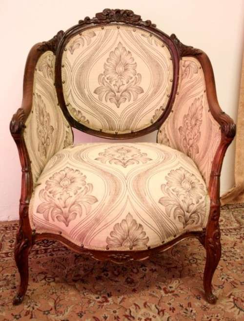 An elegant hand carved Victorian arm chair with gorgeous new fabric.