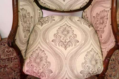 An elegant hand carved Victorian arm chair with gorgeous new fabric.