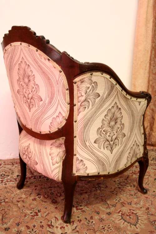 An elegant hand carved Victorian arm chair with gorgeous new fabric.