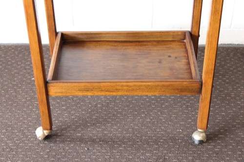 A superb Mahogany and Teak tea trolley with removable butlers tray, brass hinges on original castors