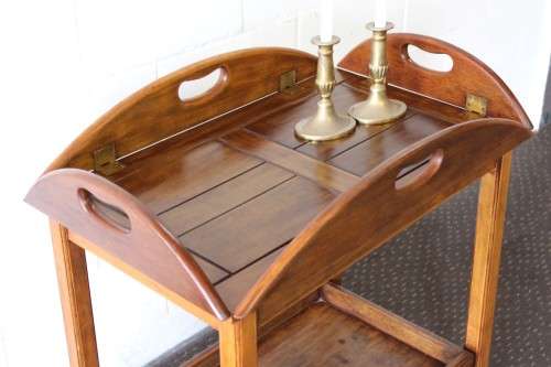 A superb Mahogany and Teak tea trolley with removable butlers tray, brass hinges on original castors