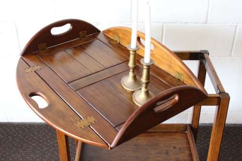 A superb Mahogany and Teak tea trolley with removable butlers tray, brass hinges on original castors