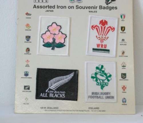 An awesome "1995 Rugby World Cup" commemorative jug and 16 iron on badges on display cards