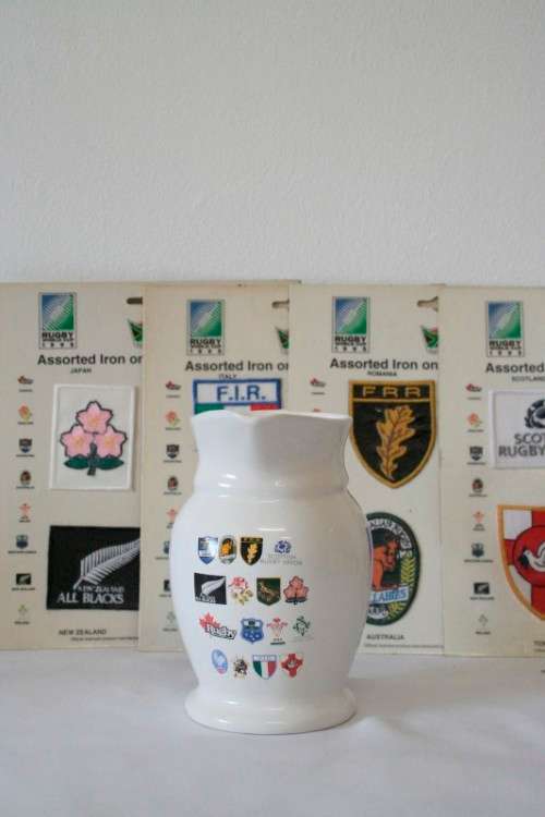 An awesome "1995 Rugby World Cup" commemorative jug and 16 iron on badges on display cards