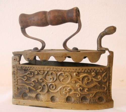 A fabulous very ornate antique brass sad iron/coal iron. Stunning as a display piece.