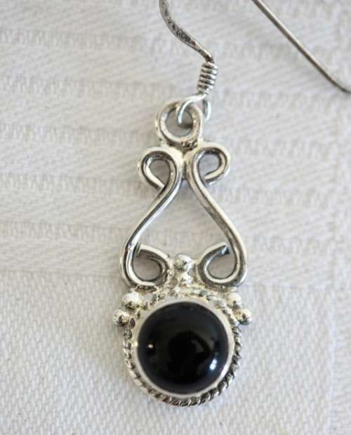 A beautiful sterling silver (925) earring set with round raised onyx stones and ornate detailing