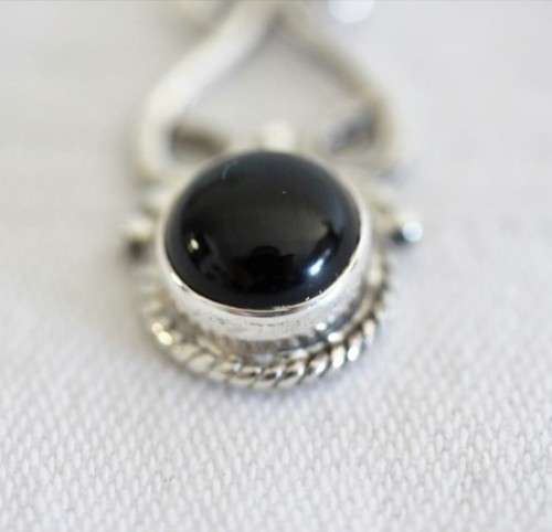 A beautiful sterling silver (925) earring set with round raised onyx stones and ornate detailing
