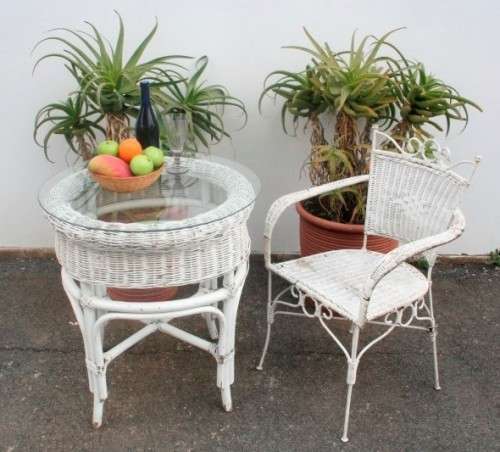 A gorgeous white painted wicker "all weather" outdoor/ patio table with a glass top and a chair