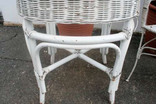 A gorgeous white painted wicker "all weather" outdoor/ patio table with a glass top and a chair
