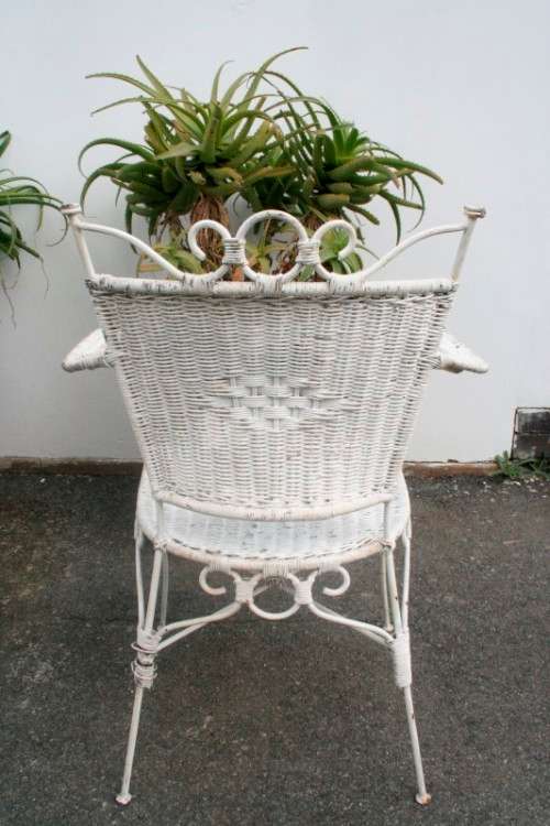 A gorgeous white painted wicker "all weather" outdoor/ patio table with a glass top and a chair