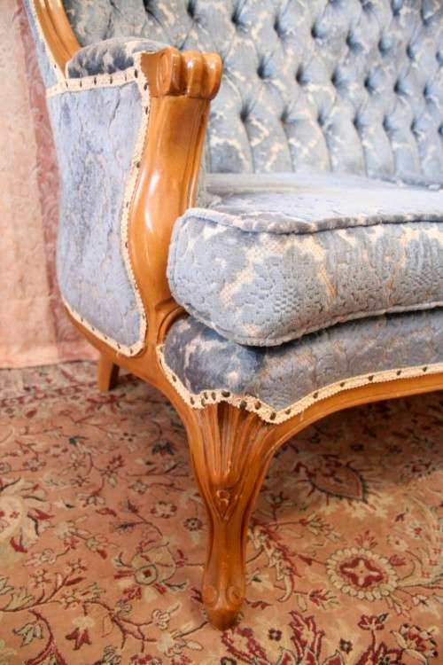 2 beautiful, elegant carved Victorian sofas with deep button detailing and blue period style fabric.