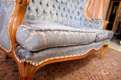 2 beautiful, elegant carved Victorian sofas with deep button detailing and blue period style fabric.