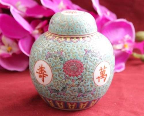 A beautiful and detailed jade-green oriental ginger jar & lid with hand painted symbols and flowers