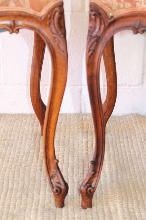 A stunning pair of hand carved ladies parlour chairs with a beautiful pink & cream brocade fabric