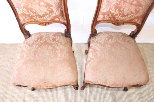A stunning pair of hand carved ladies parlour chairs with a beautiful pink & cream brocade fabric