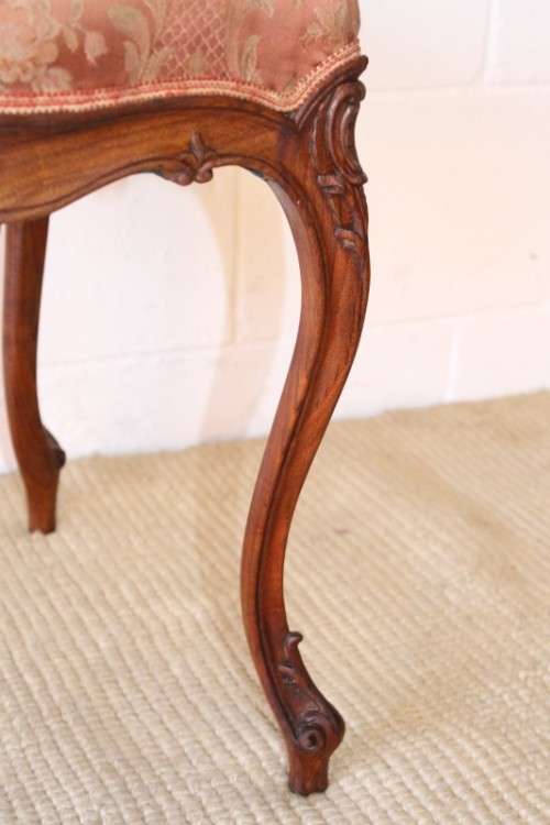 A stunning pair of hand carved ladies parlour chairs with a beautiful pink & cream brocade fabric