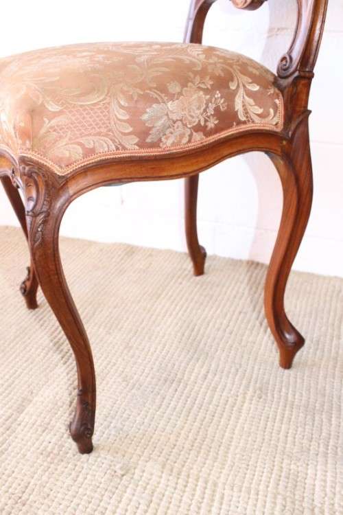 A stunning pair of hand carved ladies parlour chairs with a beautiful pink & cream brocade fabric