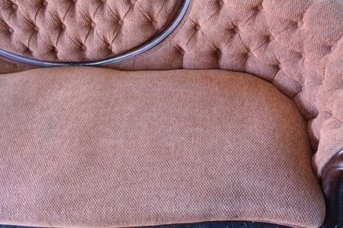 A beautiful antique Victorian Walnut deep-button camel-back sofa with stunning hand-carved detailing