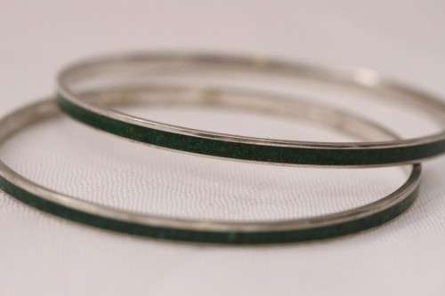 **RS17** A pair of silver metal ladies bangles with a dark green resin inlay band in good condition