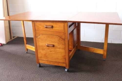A stunning & unusual vintage oak drop-leaf dining table with a cupboard and three storage drawers
