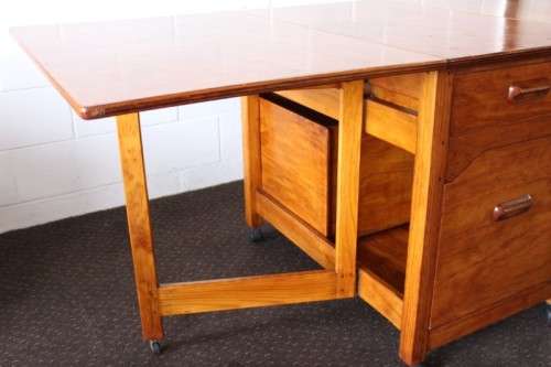 A stunning & unusual vintage oak drop-leaf dining table with a cupboard and three storage drawers
