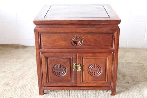 A beautifully carved oriental Elm wood "end" cupboard with brass symbol handles and a drawer