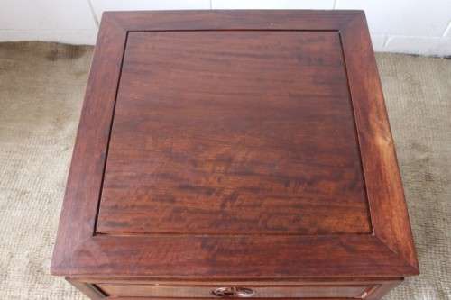 A beautifully carved oriental Elm wood "end" cupboard with brass symbol handles and a drawer