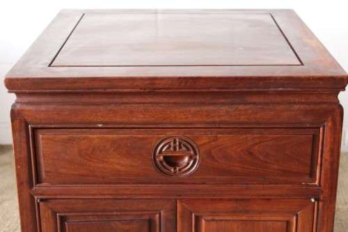 A beautifully carved oriental Elm wood "end" cupboard with brass symbol handles and a drawer