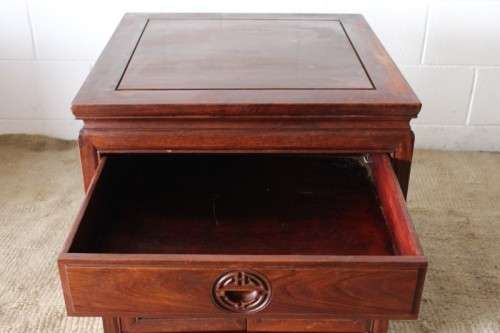 A beautifully carved oriental Elm wood "end" cupboard with brass symbol handles and a drawer