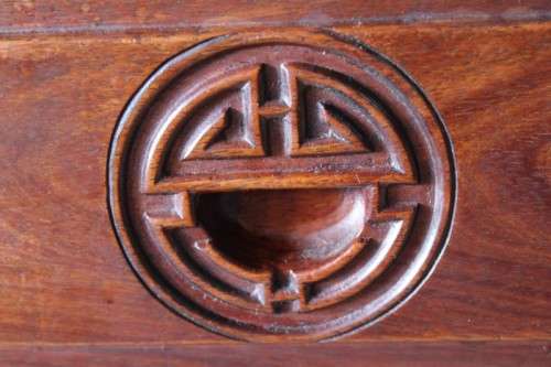 A beautifully carved oriental Elm wood "end" cupboard with brass symbol handles and a drawer