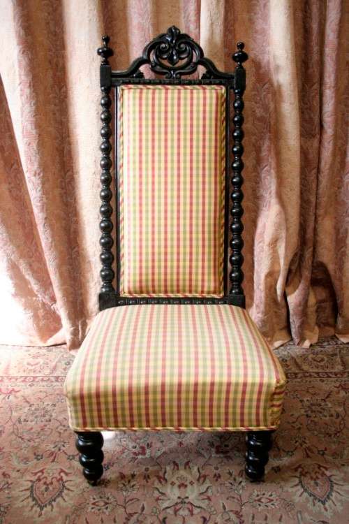 **RS17** A gorgeous Victorian "parlour chair" w/ carved detailing & chequered upholstery on castors.