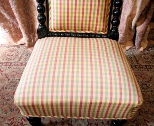 **RS17** A gorgeous Victorian "parlour chair" w/ carved detailing & chequered upholstery on castors.