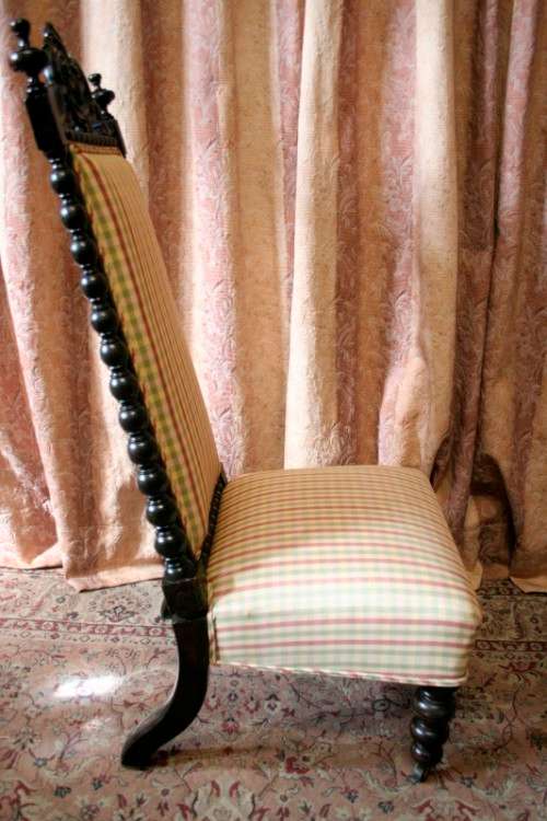 **RS17** A gorgeous Victorian "parlour chair" w/ carved detailing & chequered upholstery on castors.