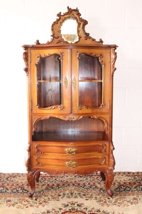 A beautiful antique French Mahogany cabinet with curved glass doors and a bevelled glass mirror