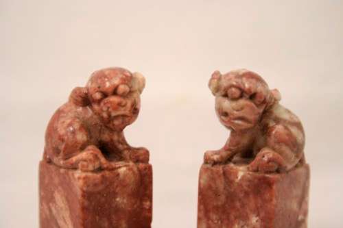 An incredible boxed pair of hand carved red-marble Feng Shui Foo Dog/ Temple Lion ornaments