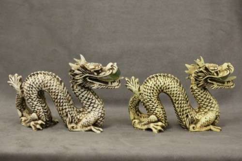 A stunning pair of Japanese ivorine resin dragons figurines with a crystal ball in their mouths