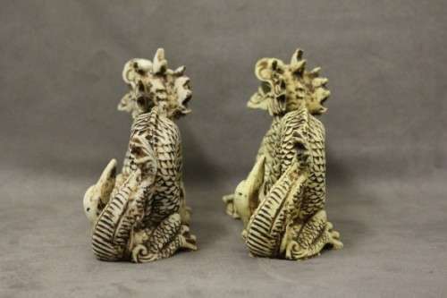 A stunning pair of Japanese ivorine resin dragons figurines with a crystal ball in their mouths
