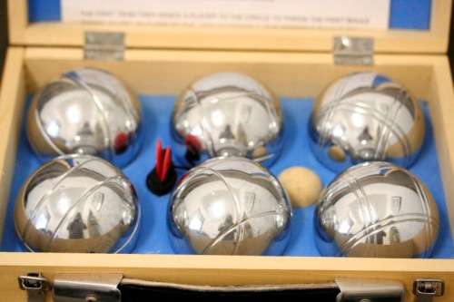An awesome set of six chrome Chinese Boule balls in a wooden case with instructions for play.