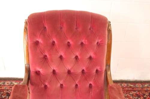 A stunningly hand carved antique walnut "Art Nouveau" reading chair with deep button detailing