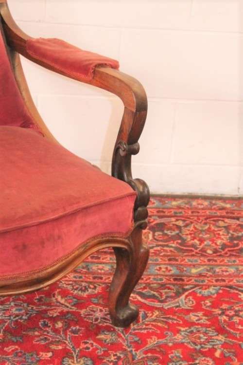A stunningly hand carved antique walnut "Art Nouveau" reading chair with deep button detailing