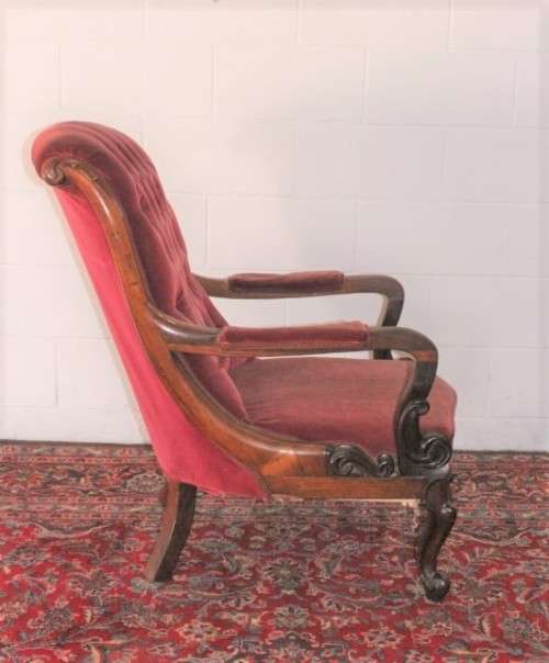 A stunningly hand carved antique walnut "Art Nouveau" reading chair with deep button detailing