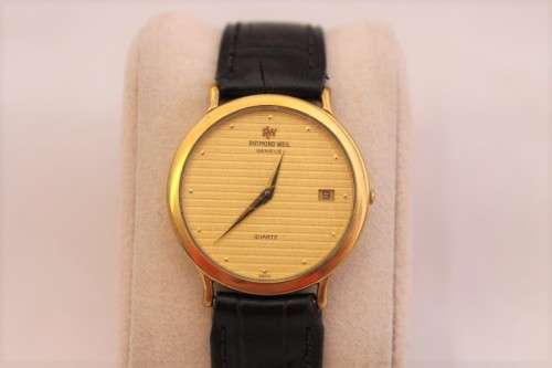 A stunning classic Raymond Weil gold plated gents quartz wrist watch with a black leather strap