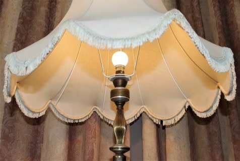 A beautiful decorative marble and brass free standing floor lamp with a large shade.