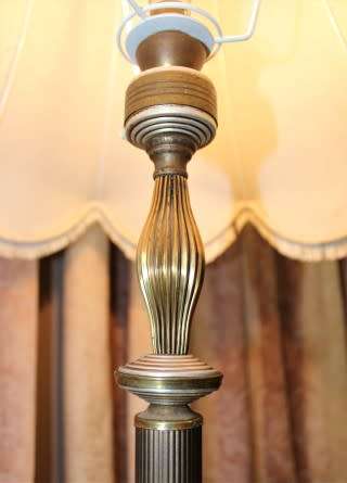 A beautiful decorative marble and brass free standing floor lamp with a large shade.