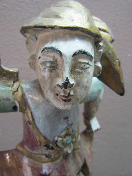 A carved ornamental Oriental wood figurine in traditional dress on a wood base. Lifespace Sale