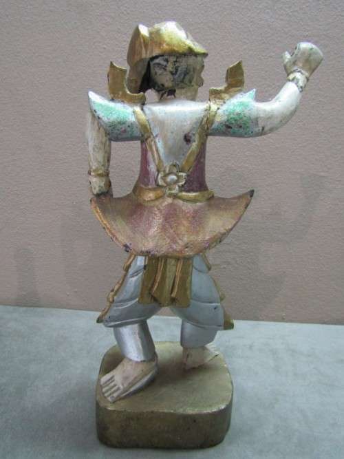 A carved ornamental Oriental wood figurine in traditional dress on a wood base. Lifespace Sale