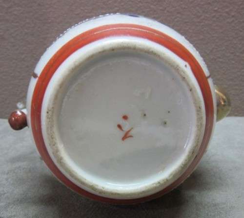 A gorgeous little oriental porcelain tea pot, with gold gilt. Stunning in a kitchen cabinet!