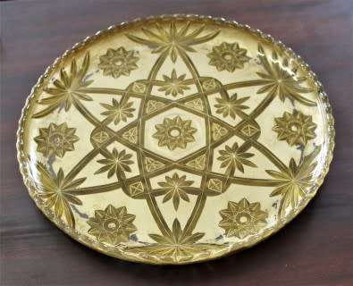 An eye-catching, round gold-coloured glass tray, with a beautiful pattern. Perfect on display!